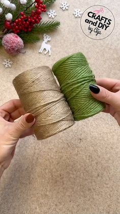 two hands holding spools of twine on top of a table next to christmas decorations