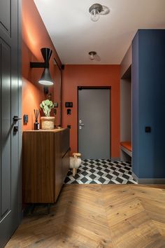 an orange and blue hallway with wooden flooring, black accents and white checkered tile