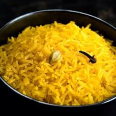 a pan filled with yellow rice on top of a stove