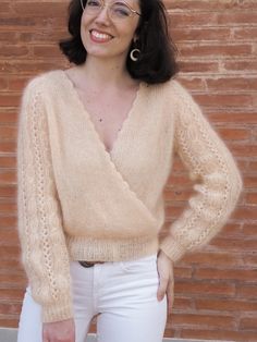 a woman wearing glasses is standing in front of a brick wall with her hands on her hips