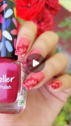 a person holding a red and pink manicure with flower designs on the nail polish