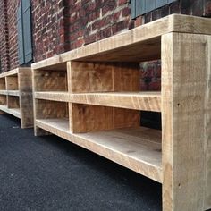 three wooden shelves sitting next to each other in front of a brick building