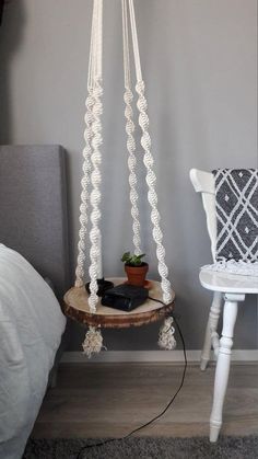 a white chair sitting next to a table with a potted plant on it