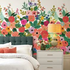 a bedroom with floral wallpaper and white bed in front of a green headboard