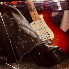 a pair of black boots and a red guitar