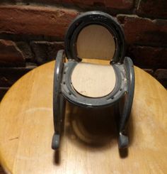 an old fashioned chair sitting on top of a wooden table next to a brick wall