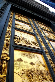 an ornate gold and black door with pictures on it