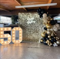 the 50th birthday party is decorated with balloons, lights and letters that spell out 50