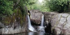 there is a waterfall in the middle of some rocks