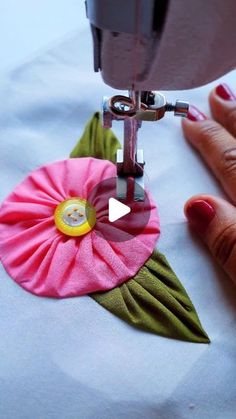 someone using a sewing machine to sew a flower