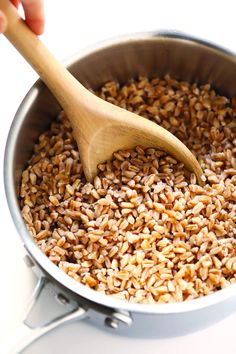 a wooden spoon in a pot full of brown rice