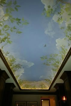 the ceiling is painted with leaves and clouds