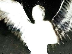 an angel with white wings standing in the dark