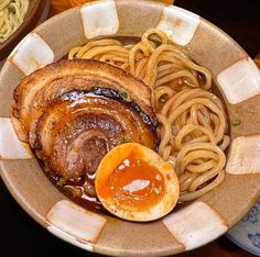 a bowl filled with noodles, meat and sauce