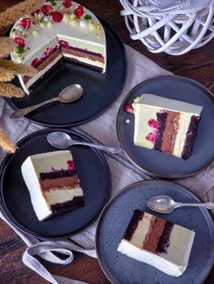 three slices of cake on black plates with silver spoons and forks next to it