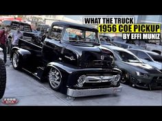 an old black truck parked next to other cars in a parking lot with the words what the truck 1950 coe pick up by eff nunz