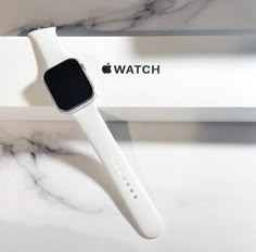 an apple watch sitting on top of a white box next to a marble countertop