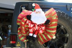 a santa clause wreath hanging on the back of a truck's tire rims