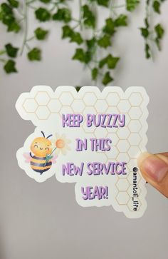 someone holding up a sticker that says keep buzzzy in this new service year