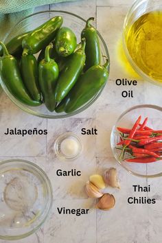 the ingredients to make green chili are displayed in bowls on a marble counter top, including garlic, jalapenos, salt, garlic, and oil