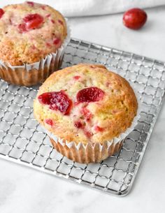 two cranberry muffins on a cooling rack