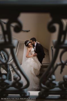 a bride and groom kissing on the stairs