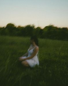 a woman sitting in the middle of a field