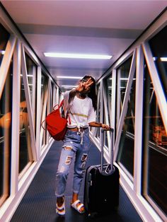 a woman is walking down the hallway with her luggage