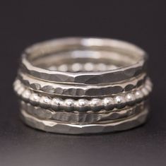 A handmade sterling silver stacking rings set, perfect for everyday use.  This is a set of 5 dainty silver stackable rings, as shown in the photos. The set includes: 2 rings made from 1.5mm wide sterling silver, hammered in a faceted pattern 2 rings made from 1.5mm wide sterling silver, hammered in a ridged pattern 1 ring made from 2mm wide sterling silver pearl ball wire The stackable rings shown in the photos have a shiny polish finish but they can also be made with a satin finish. Please leave me a note during the checkout process if you would prefer a satin/matte finish. If you would like to purchase a custom set of 1-4 stackable rings, please use this listing: https://www.etsy.com/listing/249341418/sterling-silver-rings-stacking-rings  SIZING: We have given US size options but are ver Silver Rings Women, Stacking Rings Silver, Ladies Silver Rings, Rings Dainty, Rings Stacking, Dainty Rings, Stackable Rings Silver, Rings Sterling Silver, Faceted Ring