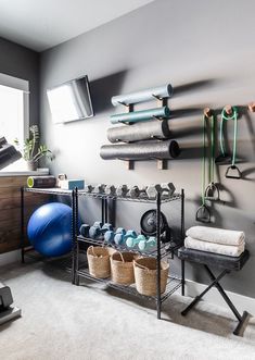 there is a gym room with exercise equipment on the wall