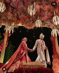 the bride and groom are shaking hands in front of an elaborate floral display at their wedding