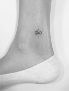 a small lotus tattoo on the ankle