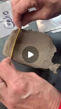 two hands are working on a piece of wood