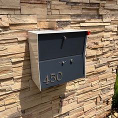 a mailbox mounted to the side of a stone wall