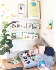 a small child is sitting on a bean bag chair in the corner of a room filled with books