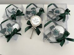 four clear gift boxes with green bows on them