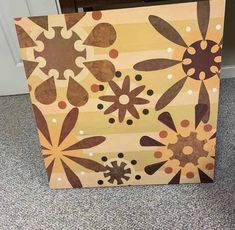 a wooden box sitting on the floor with flowers painted on it's front side