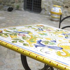 a yellow and blue table sitting on top of a stone floor