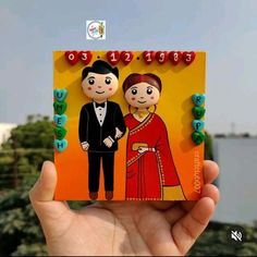 a hand holding up a small card with an image of a man and woman on it