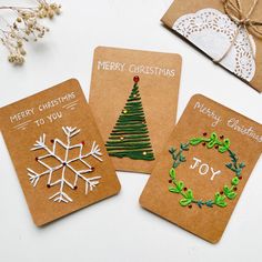 three christmas cards are sitting on a table