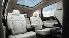 the interior of a vehicle with white leather seats and sunroofs on it