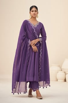 Purple scallop trim neckline anarkali, highlighted with mirror work neckline and cuffs. Paired with a scallop trim, mirror work pant and dupatta.
Components:3
Pattern:Embroidery
Type of Work:Mirror
Neckline:V Neck
Sleeve Type:Full Sleeves
Fabric:Kurta and Pant: Cotton Silk, Dupatta: Organza, Inner Lining: Crepe
Color:Purple
Other Details:
Scallop trim, mirror work dupatta
Occasion:Sangeet,Mehendi and Haldi - Aza Fashions Traditional Kurta Sets For Women, Purple Suit Set, Anarkali Sets For Women, Purple Kurta Set Women, Customised Dress For Women, Anarkali Dress With Plazo, Purple Suit Design For Women, Purple Kurta Woman, Light Purple Suit Women Indian