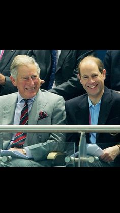 two men sitting next to each other at a tennis match