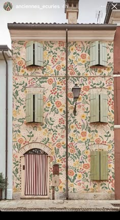 an old building painted with flowers and shutters