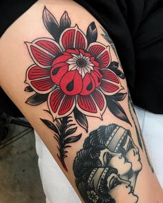 a woman's arm with a flower and ladybug tattoo on it