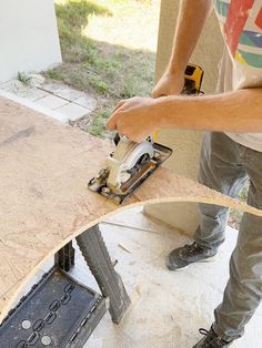 a man using a circular saw to cut plywood planks with a power tool