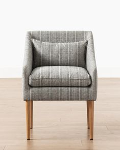 a gray chair sitting on top of a hard wood floor