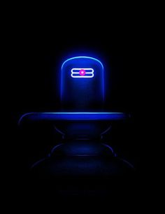 a chair that is lit up in the dark with blue light on it's back