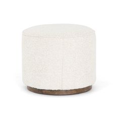 a small white ottoman with wood trim