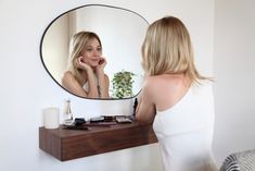 a woman looking at her reflection in the mirror